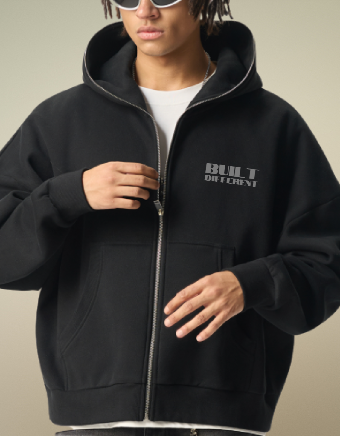 Person wearing a black hoodie with 'Built different' printed on it, standing against a neutral background.