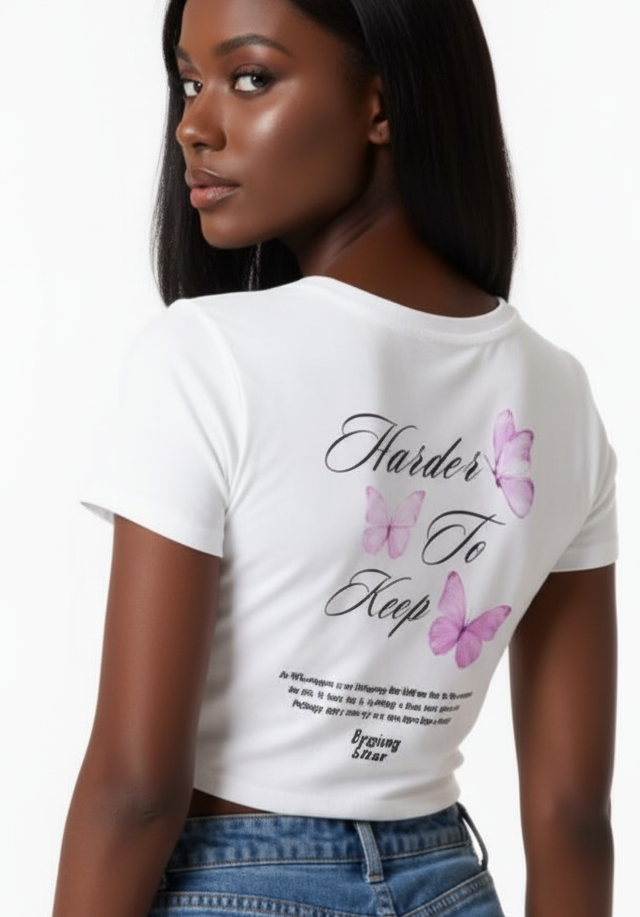 Woman wearing a white t-shirt with text and graphics, paired with blue denim shorts.